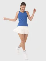 Conjunto deportivo compuesto por una musculosa azul de corte atlético y una pollera blanca plisada de estilo tenista.