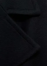 Abrigo largo de lana italiana Manteco, diseño oversize con cuello de solapa, cierre frontal de botones y cinturón desmontable. Presenta mangas largas con hebillas decorativas en los puños, dos bolsillos laterales y abertura posterior en el bajo.