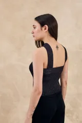 Top de tejido de punto negro con hilos metalizados multicolores, de corte ajustado al cuerpo y escote cruzado tipo halter.