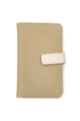 Billetera compacta de cuerina color bordó con textura granulada, solapa de cierre con broche magnético en tono marrón y costuras decorativas contrastantes.
