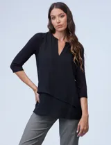 Blusa negra de tejido combinado, con diseño de capas superpuestas en la parte delantera de gasa y mangas tres cuartos de modal. Presenta un escote pronunciado en V con abertura tipo hendidura en el cuello.