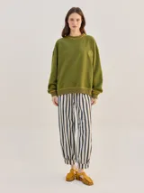 Pantalón tipo bombacha de campo color beige, de corte holgado con pinzas en la cintura y puños ajustados en los tobillos. Presenta costuras a contratono y bolsillos laterales.