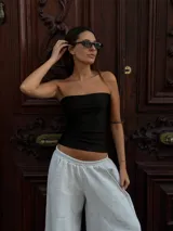 Top strapless de color negro, con diseño ajustado y corte recto, confeccionado en tela elástica.