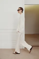 Blazer cruzado Zara Woman Collection confeccionado en hilatura de viscosa, de color blanco. Presenta cuello alto, manga larga con abertura y botones, bolsillos delanteros y cierre frontal cruzado con botones.