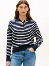 Sweater de punto trenzado Tommy Hilfiger a rayas horizontales azules y blancas, de corte amplio con hombros caídos, cuello tipo polo con solapa y botones dorados, y detalles en punto canalé en cuello, puños y bajo.