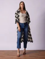 Cardigan largo de crochet color crudo con diseño de ondas en negro.