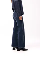 Jean de corte recto en color azul oscuro, con diseño de rayas verticales formadas por pequeños apliques brillantes a lo largo de toda la prenda.