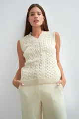 Chaleco de lana color crudo, tejido con escote en V y diseño con diferentes puntos combinados en el frente.