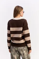 Buzo de tejido liviano con diseño de rayas horizontales en azul marino y gris, cuello tipo polo en color crema y mangas largas.