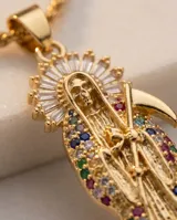 Cadena de eslabones tipo cuerda con dije de la Santa Muerte, elaborado en metal dorado con incrustaciones de circonias multicolores.
