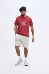 Remera blanca de manga corta con cuello redondo y estampa frontal de estilo vintage con texto inscripto.