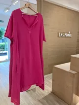 Vestido fucsia de lino estilo túnica, con escote en V, manga corta y bolsillos laterales. Más largo en la parte trasera que en la delantera.