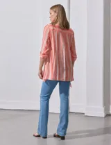 Camisa larga de rayón, con cuello clásico, cierre frontal con botones y mangas regulables con presilla. Presenta un diseño holgado con tajos laterales en el ruedo.