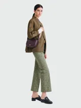 Bandolera Longchamp modelo Épure, color ciruela, con correa de tela ajustable y cierre con broche a presión.