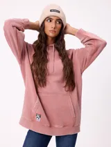 Gorro tipo beanie de punto acanalado en color beige, con parche rectangular negro con el logo de la marca en el frente.