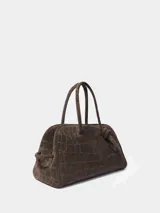 Bolso de mano Jacquemus modelo Le Turismo, confeccionado en cuero con textura de efecto cocodrilo. Presenta un diseño estructurado con asas superiores, cierre de cremallera y un detalle de nudo decorativo en uno de los laterales.