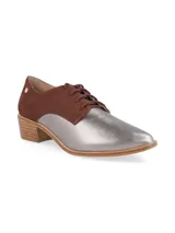 Zapatos tipo Oxford con cordones, combinados en color marrón y plateado metalizado, con taco bajo de madera.