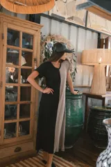 Vestido largo de punto acanalado en color negro, con escote en V, mangas cortas y aberturas laterales en el ruedo.