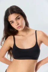 Top deportivo blanco con tirantes ajustables y diseño sin costuras.