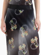 Pollera larga de mesh plisada, color negro con estampado de corazones formados por cadenas, con forrería interna y cintura elástica satinada.
