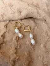 Aros tipo argolla dorada con cierre de clip, con dos perlas de río colgantes en cada uno.