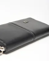 Billetera tipo fichero XL Extra Large de color negro, confeccionada en símil cuero con cierre perimetral y aplicación metálica con el logo de la marca.
