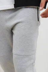 Pantalón jogging de corte slim, con puños elastizados, cintura con cordón ajustable, cierres laterales engomados y bolsillo tipo parche lateral.
