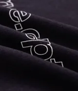 Remera de manga larga Blue Steel, color negro, con diseño de cuello redondo y corte relajado. Presenta un estampado frontal con la palabra 'WORLDWIDE' en letras blancas y detalles de líneas horizontales en contraste.