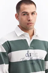 Polo de manga larga con diseño de rayas horizontales anchas en color marrón y crema. Presenta cuello camisero blanco con cartera de botones y estampado frontal con texto decorativo y logo de la marca.