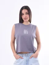 Remera sin mangas, color gris lila, de corte cropped y cuello redondo. Estampado frontal con texto que dice "BORN IN THE 90'S".