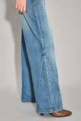 Jean de corte wide leg en color azul claro con costuras laterales diagonales y ruedo desflecado.