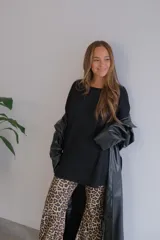 Conjunto de dos piezas compuesto por un buzo de cuello redondo y mangas largas con diseño holgado y un pantalón de corte recto y tiro alto. Ambas prendas están confeccionadas en tejido de punto acanalado.