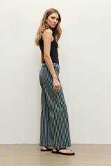 Pantalón de jean azul marino con diseño de rayas verticales blancas, tiro medio, corte acampanado y bolsillos delanteros aplicados.