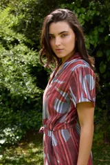 Mono de lino mezcla con estampado vegetal en tonos rojos, grises y blancos, de manga corta, escote en V y piernas amplias con cinto incorporado para ajustar la cintura.