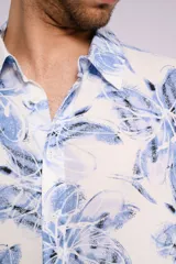 Camisa de hombre de manga corta con estampado de flores azules sobre fondo blanco, cuello clásico y cierre frontal con botones.