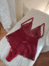 Body de encaje color rojo con escote pronunciado, breteles regulables y diseño tipo tanga en la parte inferior.