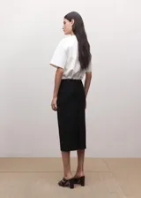 Falda midi de tiro bajo confeccionada en mezcla de lana, con trabillas, abertura posterior y cierre de cremallera en la parte trasera.