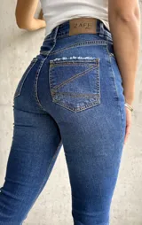 Jean de calce recto con lycra, color azul medio, con bolsillos delanteros y traseros.