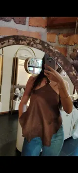 Top de cuero color marrón con diseño irregular y ajuste con cordones en la parte delantera.