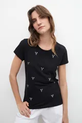 Remera blanca de algodón con cuello redondo y strass plateados formando pequeños dibujos.