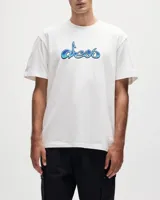 Remera blanca de manga corta con cuello redondo y un estampado frontal de estilo graffiti o caligráfico en tonos azules y celestes.