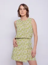Falda corta con estampado floral en tonos verde lima y blanco, con cintura elástica y corte asimétrico en el ruedo.