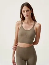 Top deportivo de sujeción media con diseño seamless y tecnología 3D. Presenta tirantes finos cruzados en la espalda y una banda elástica acanalada en la base para mayor ajuste.