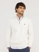 Sweater de punto con medio cierre frontal, manga larga y cuello alto. Presenta un diseño acanalado con logo bordado en el pecho.