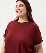 Blusa de ribana color marrón, con cuello redondo, mangas cortas y diseño holgado.