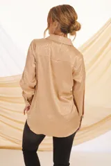 Camisa beige con estampado de líneas diagonales, cuello clásico, cierre con botones y mangas largas con puños abotonados.