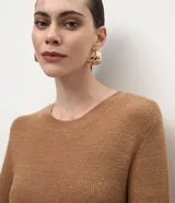 Vestido midi de punto con cuello redondo, mangas largas y falda evasé. Confeccionado en tejido de viscosa, poliéster y poliamida.