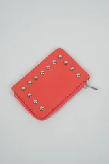 Billetera pequeña color negro con cierre de cremallera plateado y apliques de tachas metálicas redondas en la parte frontal.