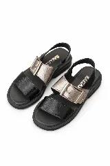 Sandalias de cuero marrón, con diseño de dos fajas amplias, una lisa en la parte delantera y otra superior con hebilla metálica grande y ajustable. Suela plana con plataforma baja y pespunte visible.