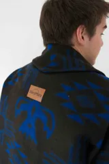 Cardigan de paño de lana con diseño de inspiración navajo en colores negro y azul. Presenta cuello smoking, cierre frontal con botones de guampa, bolsillos delanteros y puños con botón.